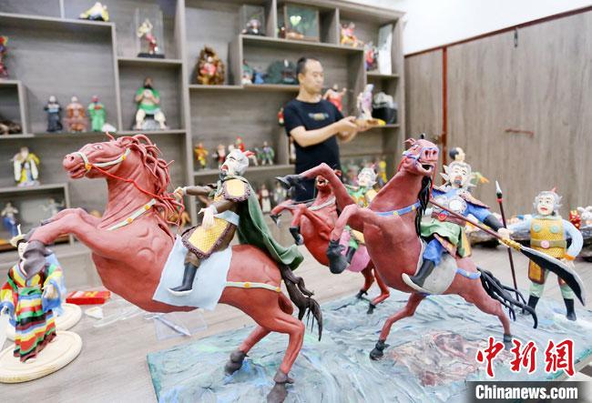 安秋平是成州面塑第五代傳承人，也是當?shù)匚ㄒ粓允孛嫠苤谱鞯娜??！「哒?攝