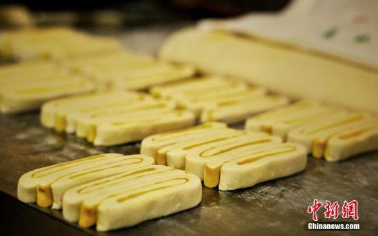 圖為面劑被涂上胡麻油，切成條狀用作月餅的花型制作。張文 攝