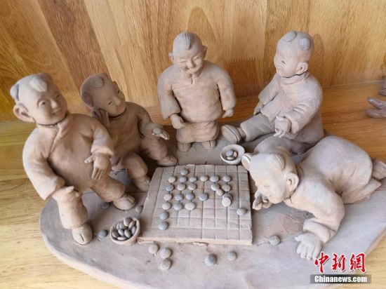 圖為泥塑作品展現(xiàn)下棋場景。 劉玉桃 攝