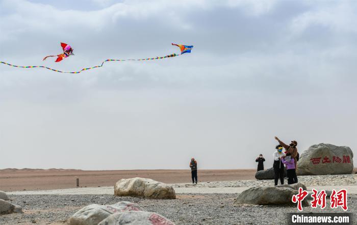 圖為市民正在陽關(guān)景區(qū)放風(fēng)箏。　王斌銀 攝