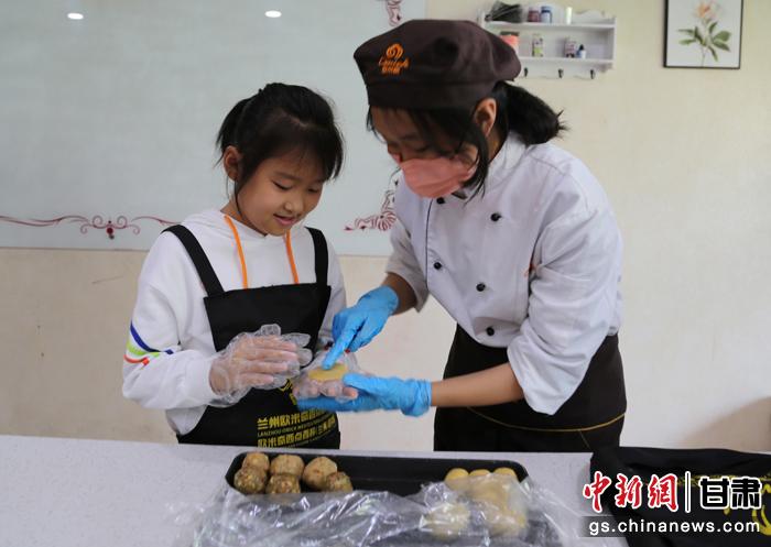 圖為在甘臺胞小朋友在工作人員指導(dǎo)下制作月餅。九美旦增 攝