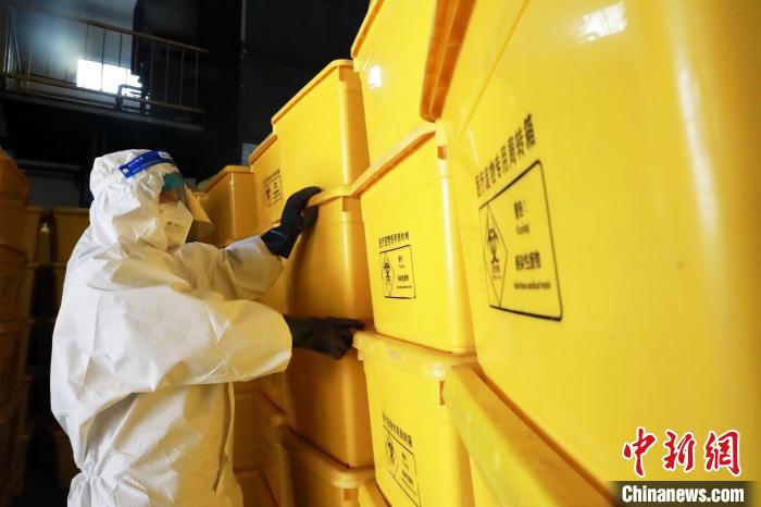 圖為工作人員搬運醫(yī)療廢物專用周轉箱?！∥航ㄜ?攝