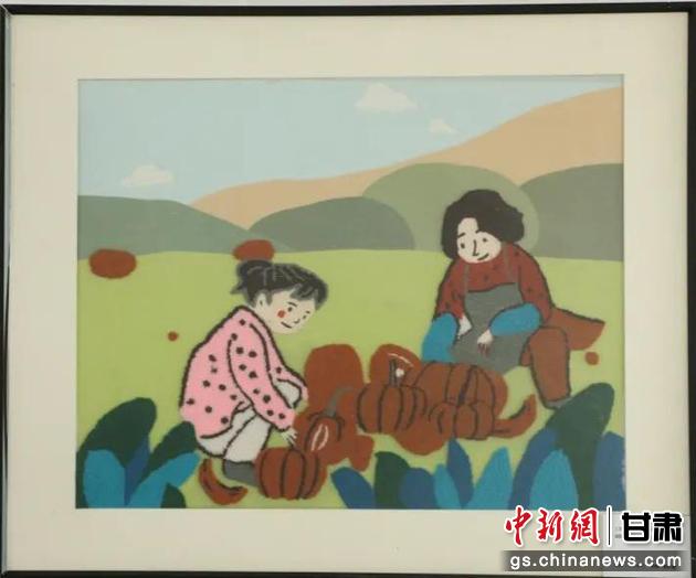 嘉峪關(guān)市新城鎮(zhèn)新城村農(nóng)業(yè)產(chǎn)業(yè)園區(qū)內(nèi)，母女兩人在摘南瓜。刺繡 馬艾米乃 繡稿 敬紅霞