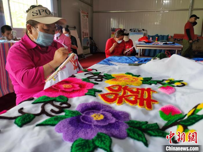 圖為婦女制作青繡?！?zhí)砀?攝