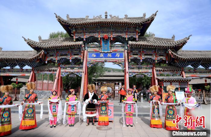 圖為身穿土族服飾的工作人員迎接訪客?！⊙Φ?攝