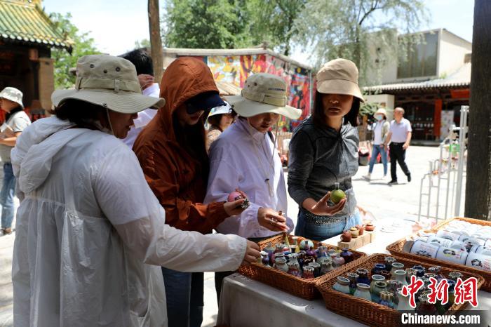 圖為民眾挑選手工藝產(chǎn)品?！⊙Φ?攝