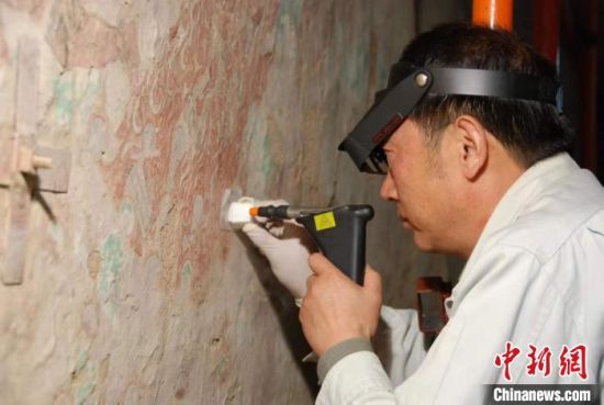 敦煌研究院研究員樊再軒進(jìn)行壁畫修復(fù)。(資料圖)張?jiān)莆?攝