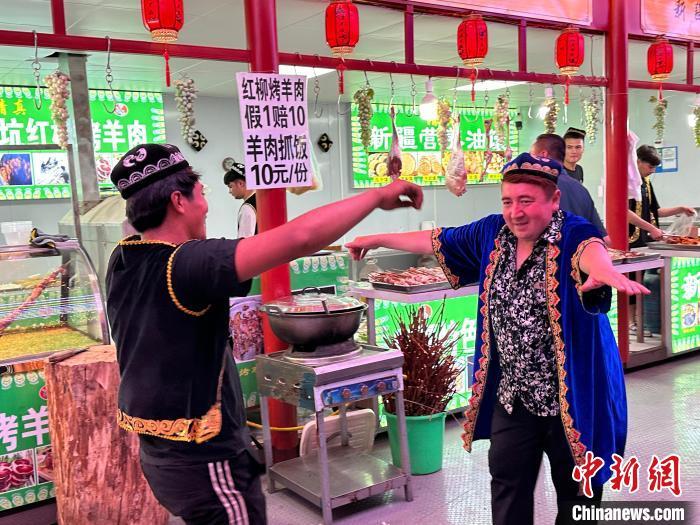 圖為餐飲經(jīng)營者在“西涼不夜城”跳起舞蹈引客?！〈魑牟?攝</p><p>