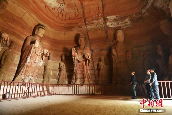 7月15日，游人參觀甘肅省平?jīng)鍪袥艽h百里石窟長廊中的南石窟寺1號窟。百里石窟長廊位于涇川縣境內(nèi)，由512個石窟、5眼窟中石井組成，現(xiàn)存王母宮石窟、鳳凰山石窟、南石窟寺、丈八寺石窟、羅漢洞石窟、太山寺石窟等規(guī)模較大的石窟群，還有數(shù)量眾多的小石窟群。南石窟寺開鑿于北魏永平三年，其中1號窟屬于大型七佛窟，七佛高達(dá)6米。中新社記者 李亞龍 攝