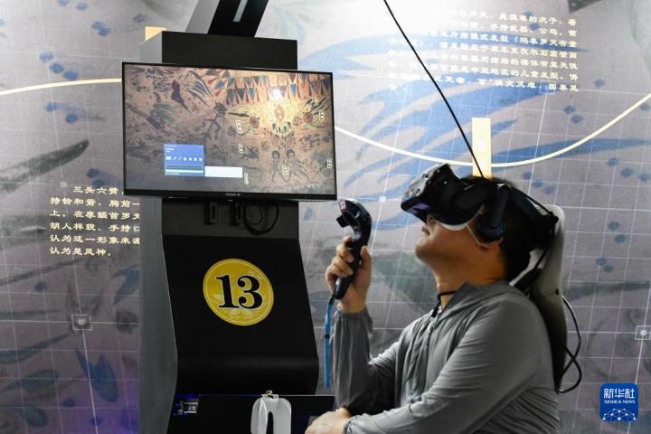 7月22日，游客借助VR設備沉浸式游覽莫高窟第285窟虛擬場景。新華社記者 郎兵兵 攝